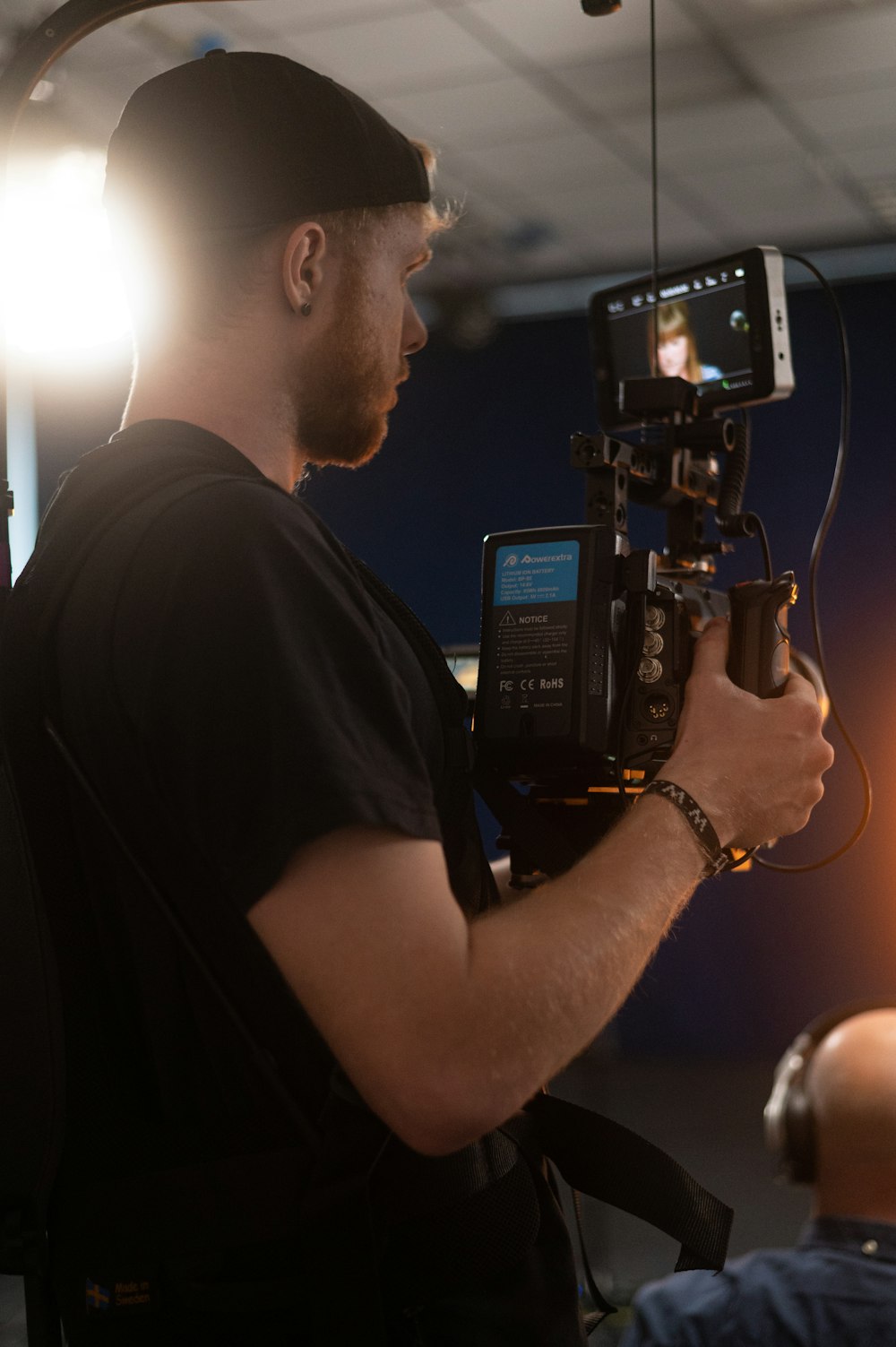 man in black t-shirt holding black video camera