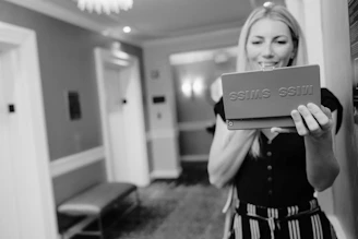 grayscale photo of woman holding box