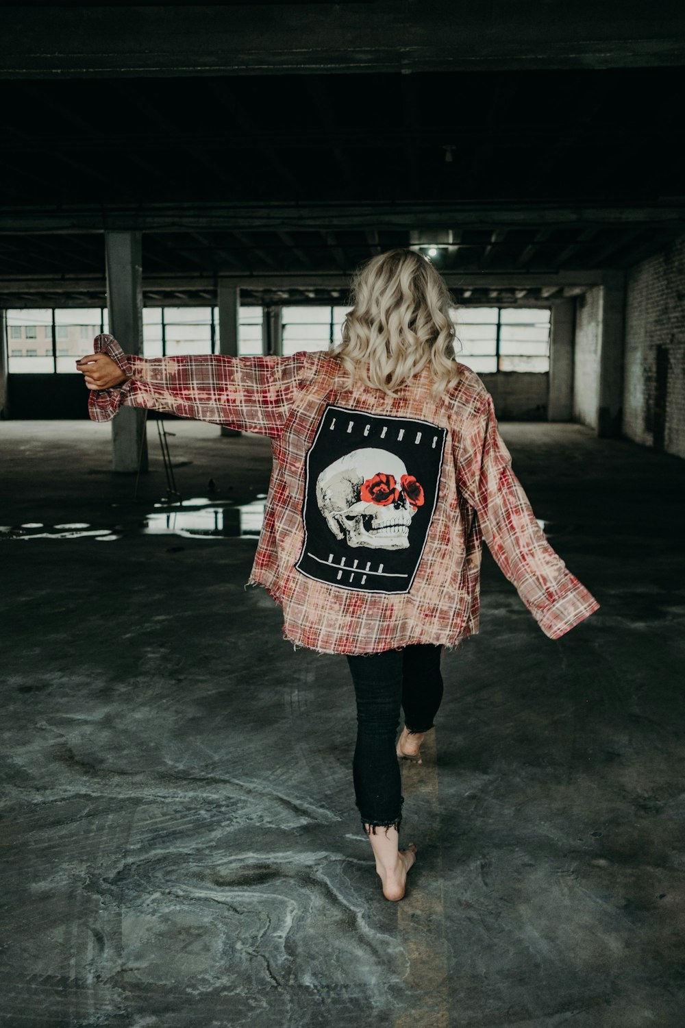 girl in red and white sweater standing on gray concrete floor