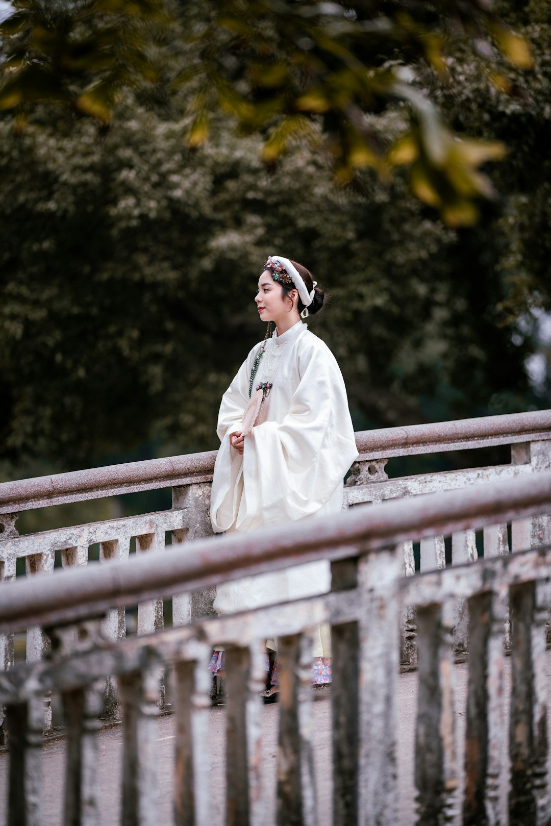 woman in white long sleeve dress wearing black sunglasses standing beside brown wooden fence during daytime