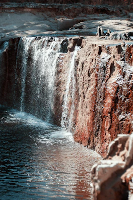 Sunset over the serene turquoise pools of Wadi Shab, framed by rugged cliffs.