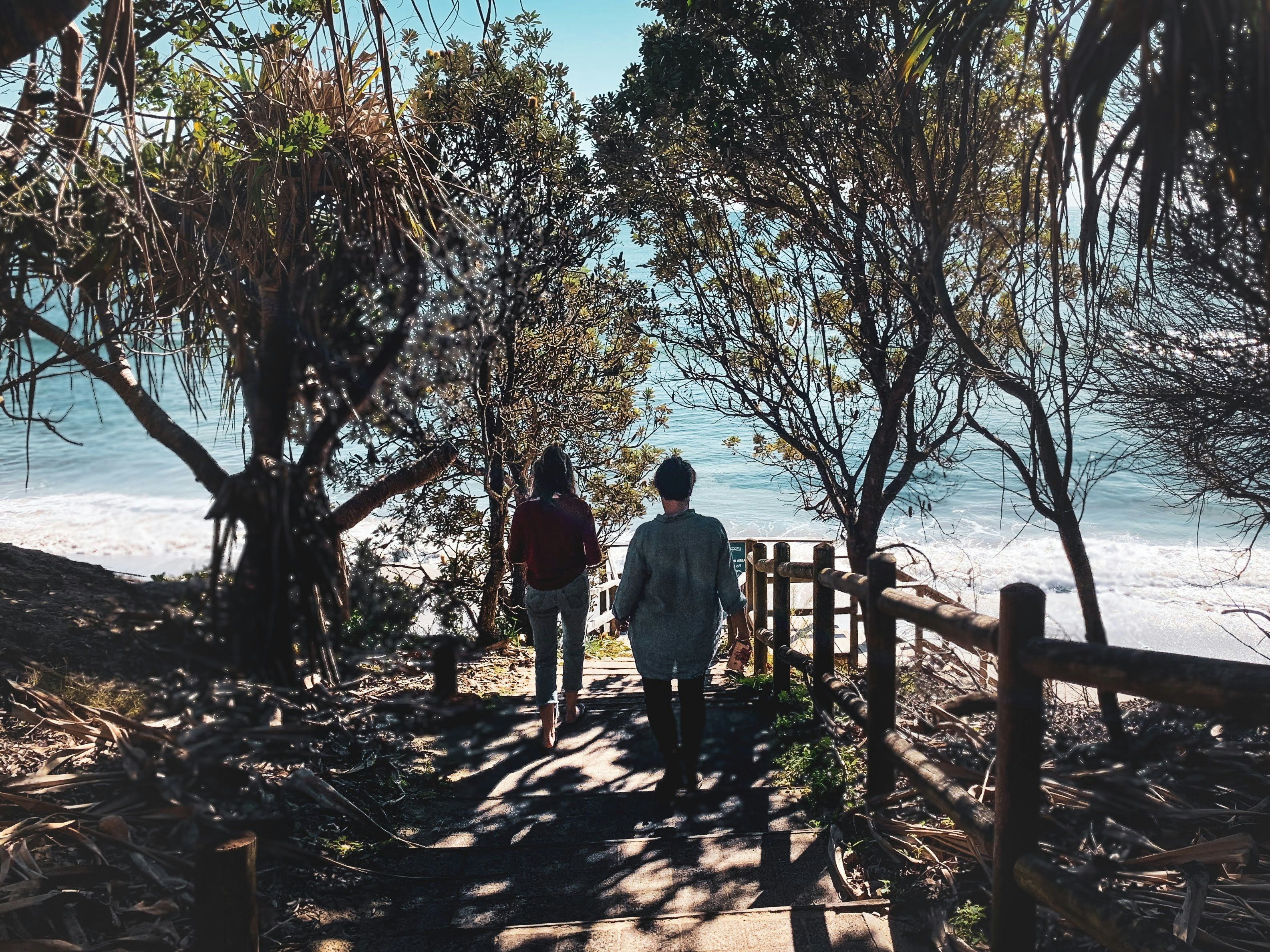 man and woman walking on beach during daytime