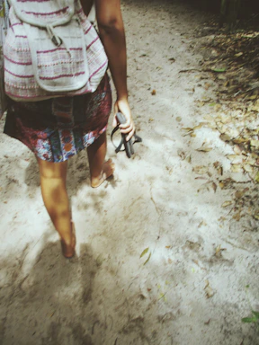 A joyful person walking confidently in unique vaca vida sandals at an outdoor summer party.