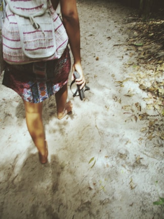 Young person walking along a sandy path wearing modern casual espadrilles.