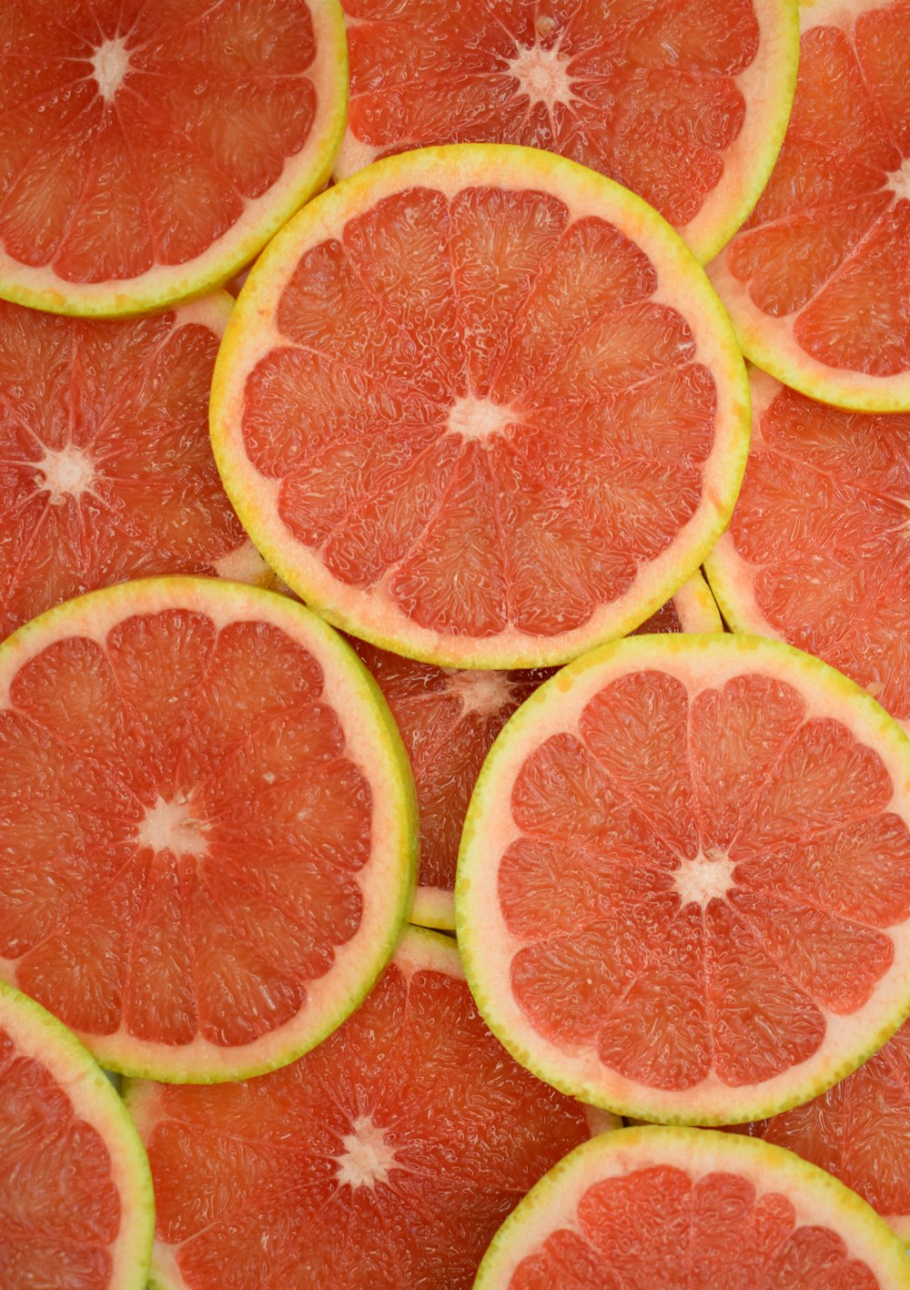in Scheiben geschnittene Orangenfrüchte auf roter Oberfläche