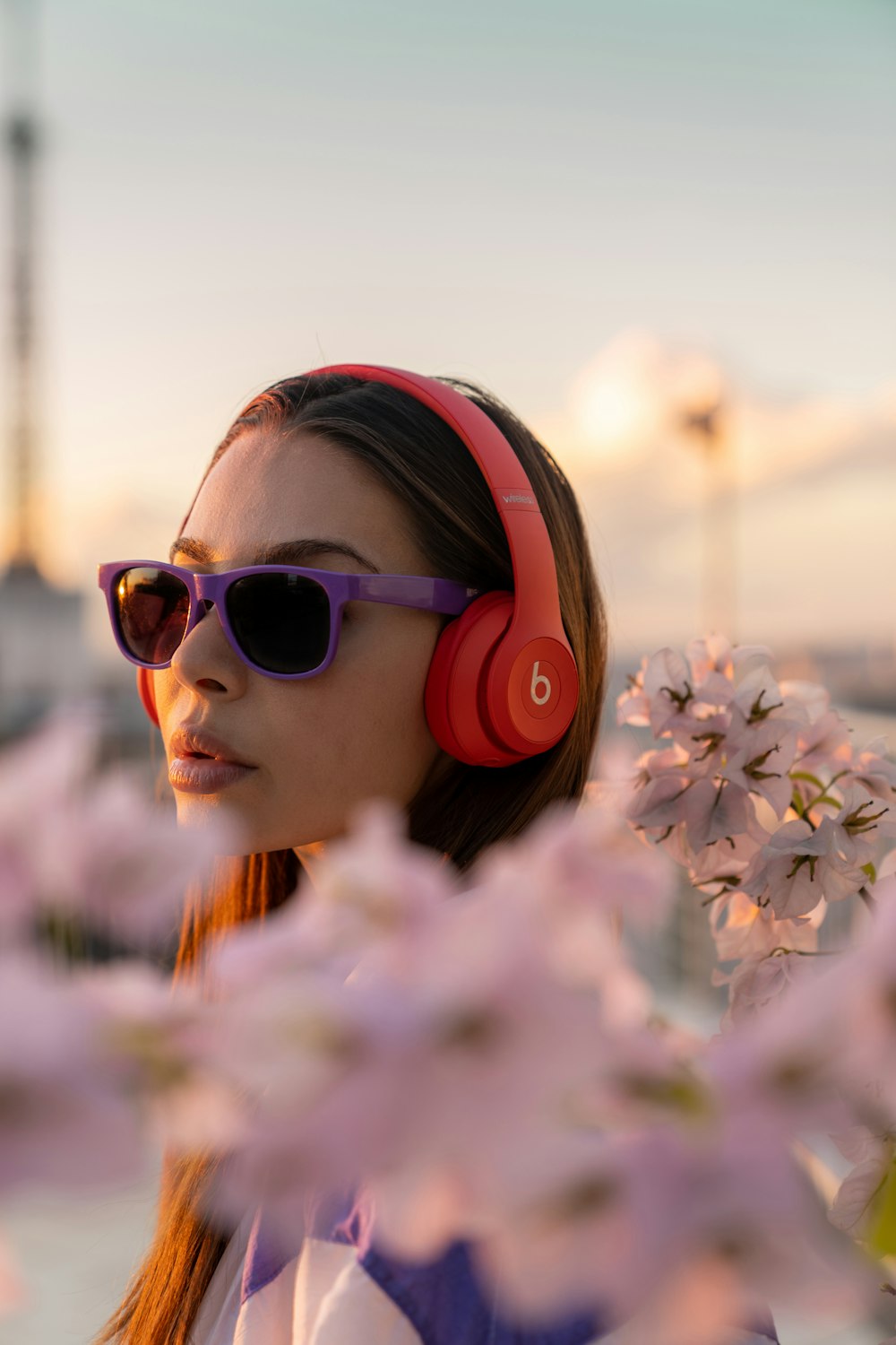 menina em óculos de sol cor-de-rosa que seguram flores brancas