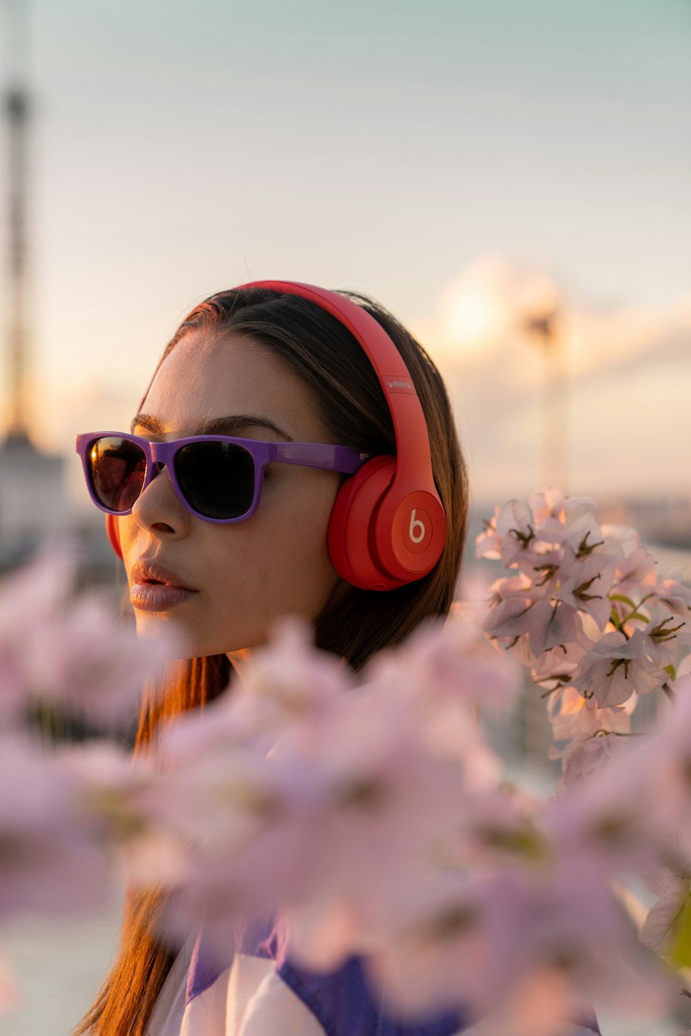 Chica con gafas de sol rosas sosteniendo flores blancas