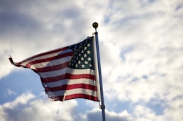 us a flag under white clouds during daytime