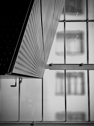 Monochrome close-up of a structured border detail on a glass partition within the office.