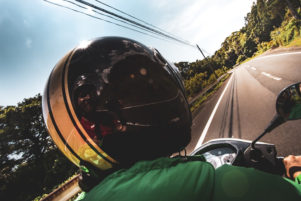 person in green jacket wearing black helmet