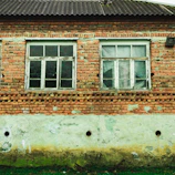 Exterior house facade after pressure washing, showing clean brickwork and brightened surfaces.