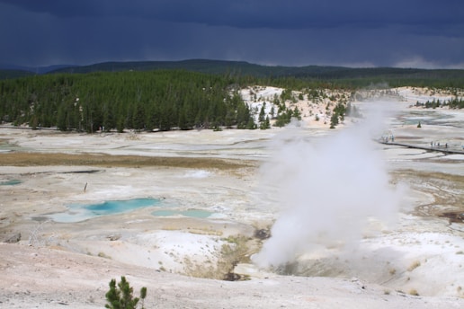 A geothermal power plant nestled in a rugged landscape with steam rising from the earth.
