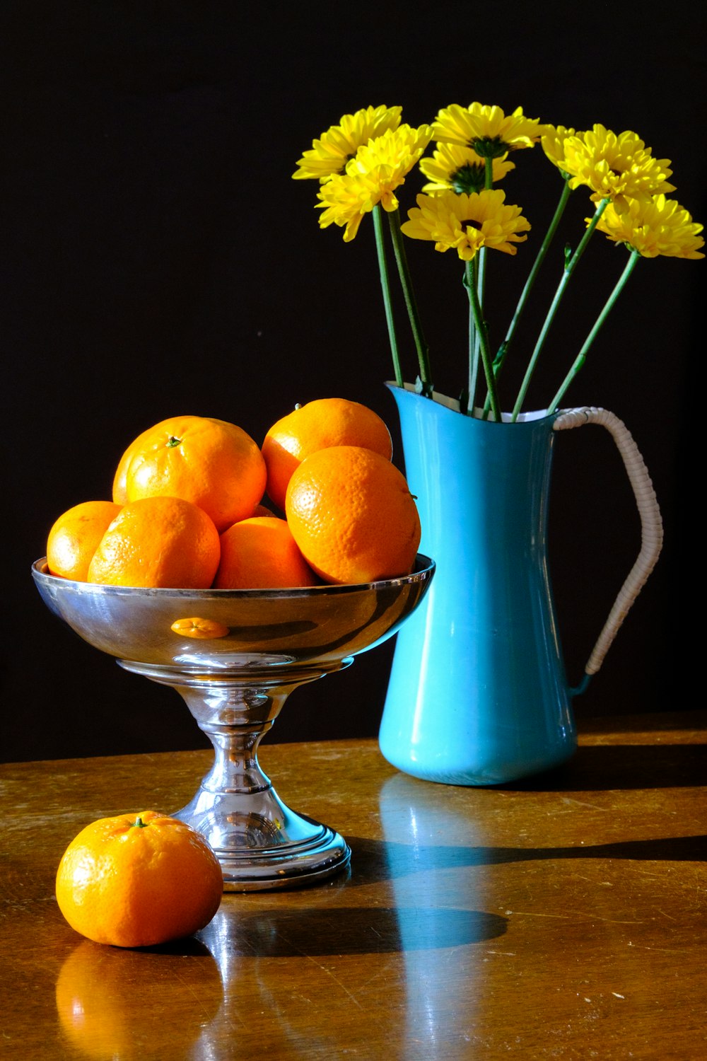 frutas naranjas en jarrón de cristal azul