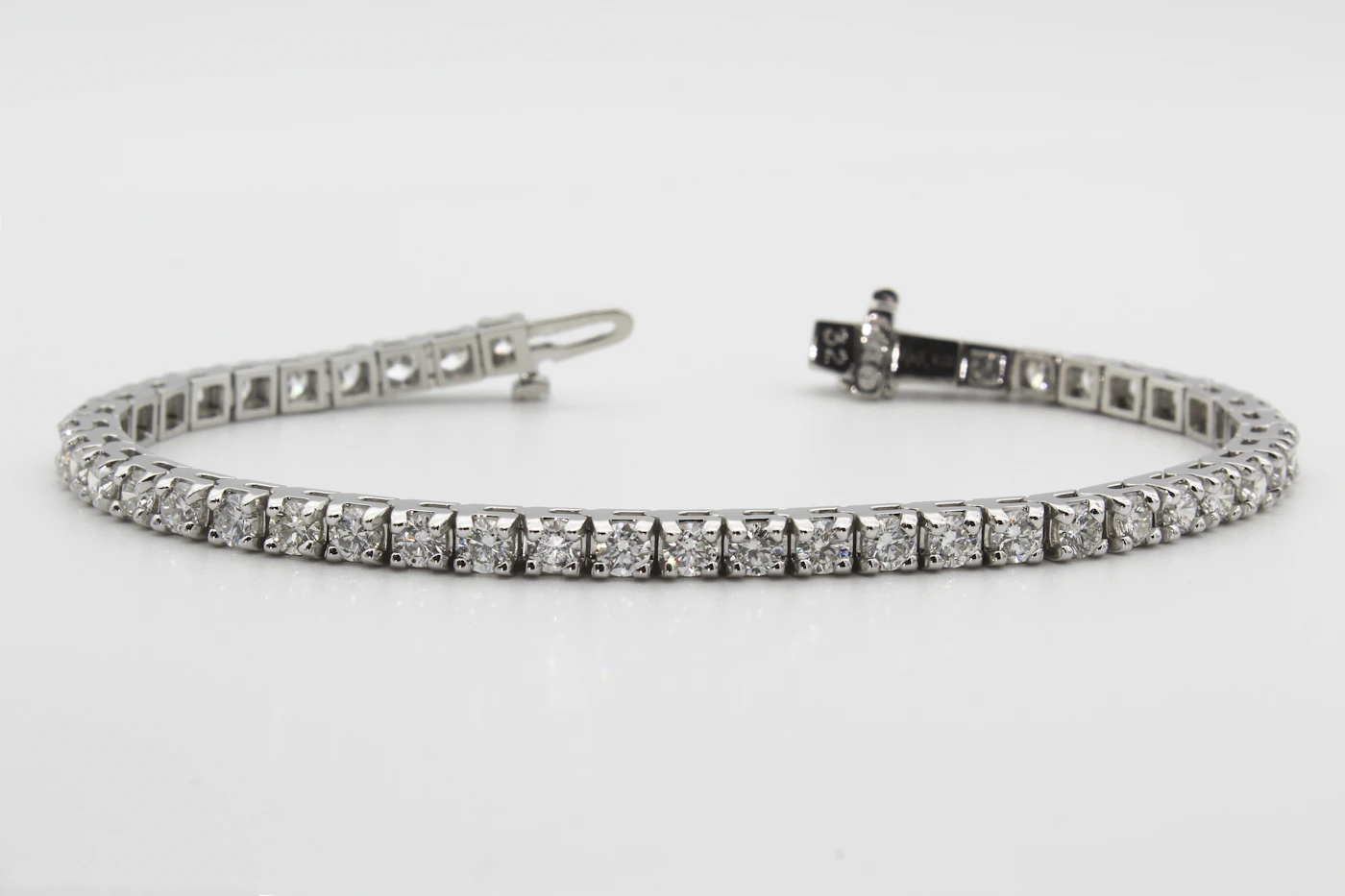 Macro photograph of the Vesta Tennis Bracelet — forty-two claw-set diamonds linked across a hairline of platinum