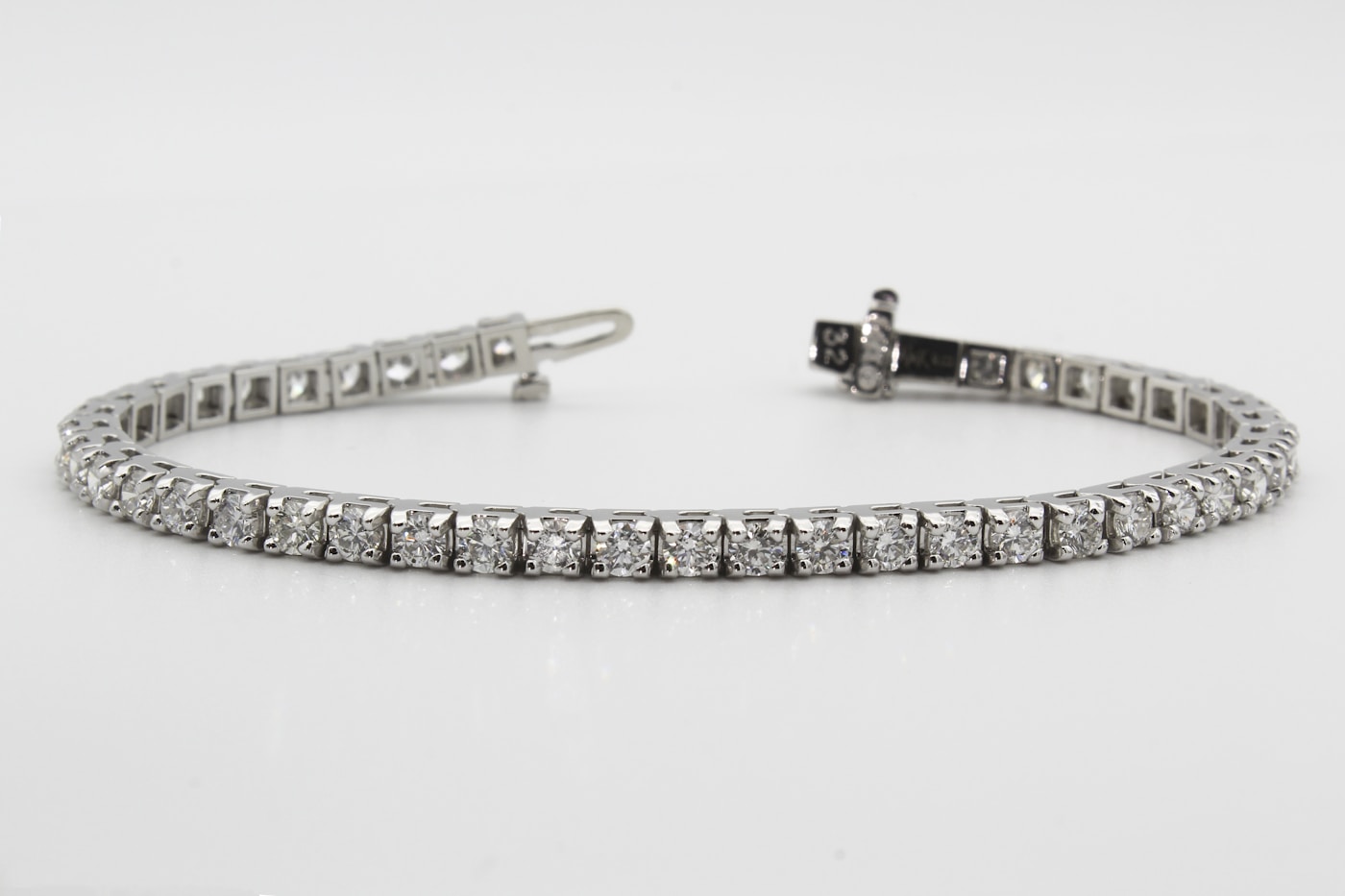 Macro photograph of the Vesta Tennis Bracelet - forty-two claw-set diamonds linked across a hairline of platinum