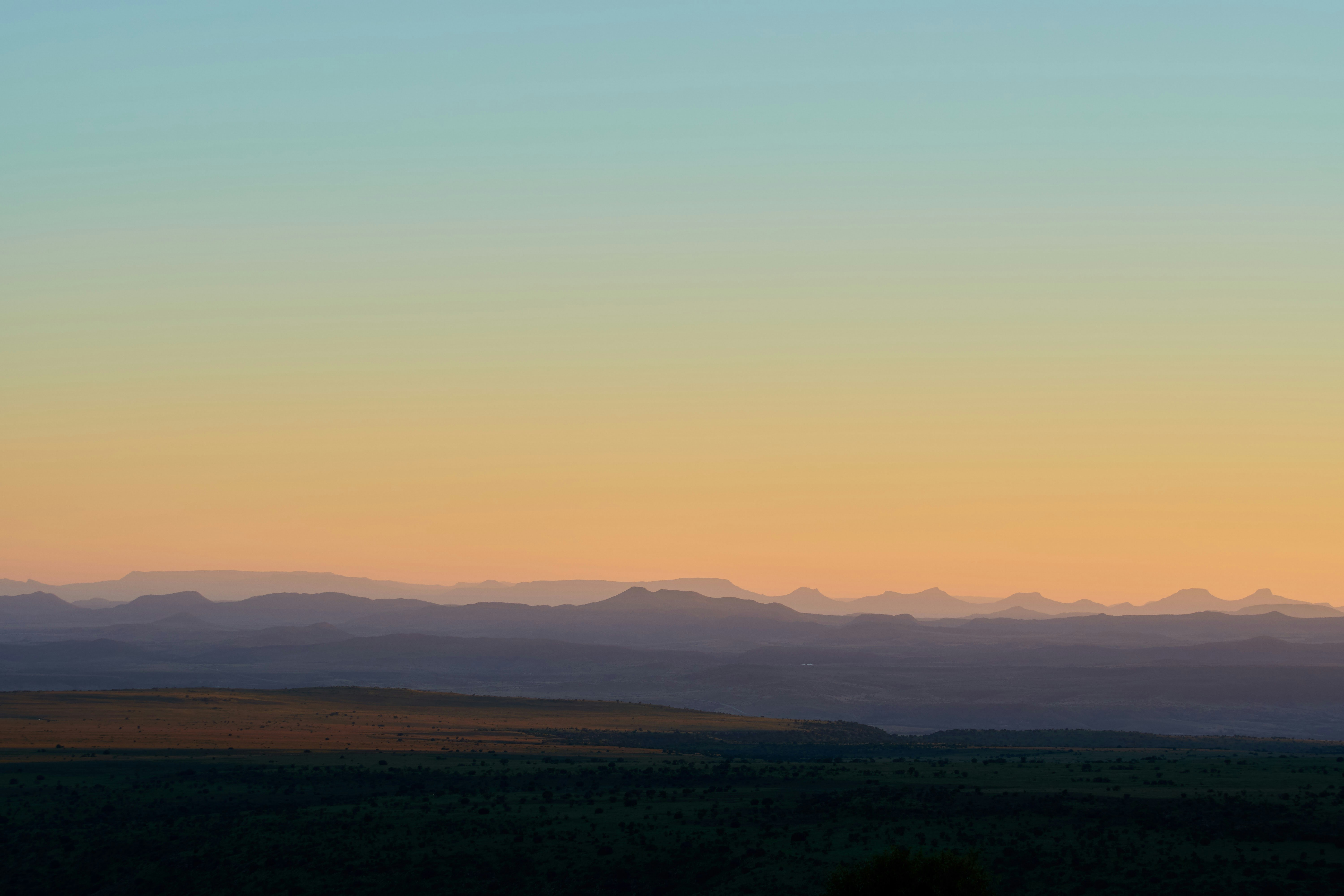 green grass field near mountain during daytime