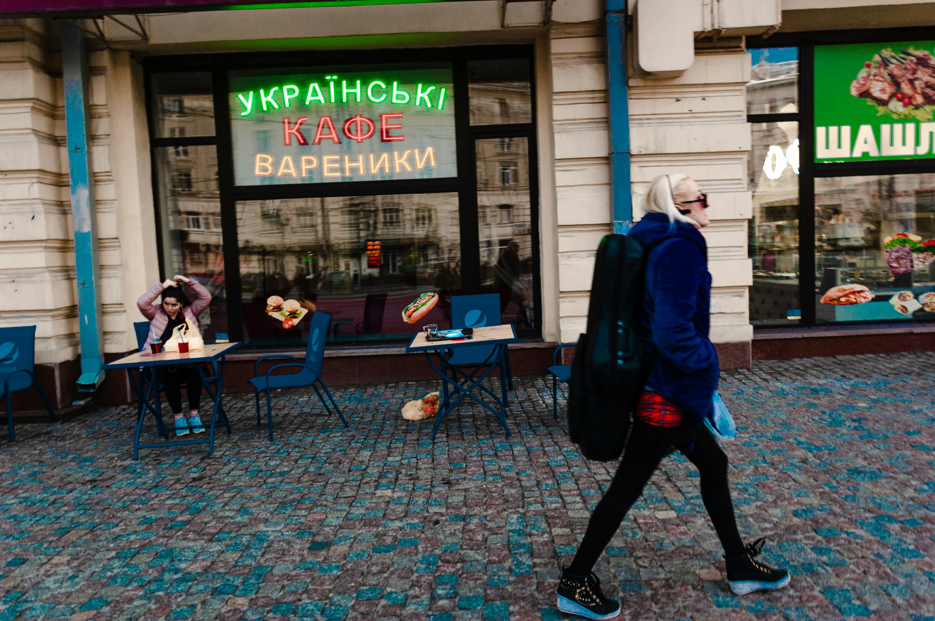 man in blue jacket walking on sidewalk during daytime
