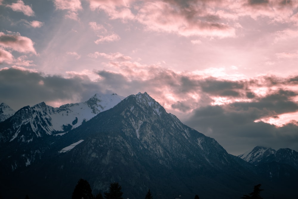 black and white mountain under white clouds