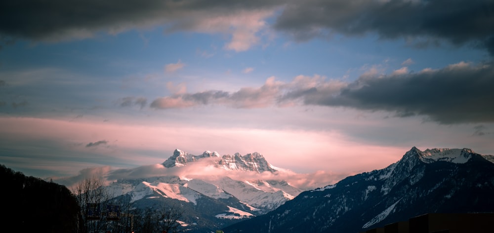 snow covered mountains under cloudy sky during daytime