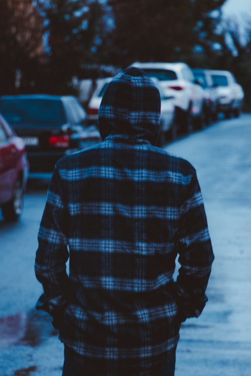 Persona con sudadera con capucha a cuadros azul y blanco de pie en la calle durante el día