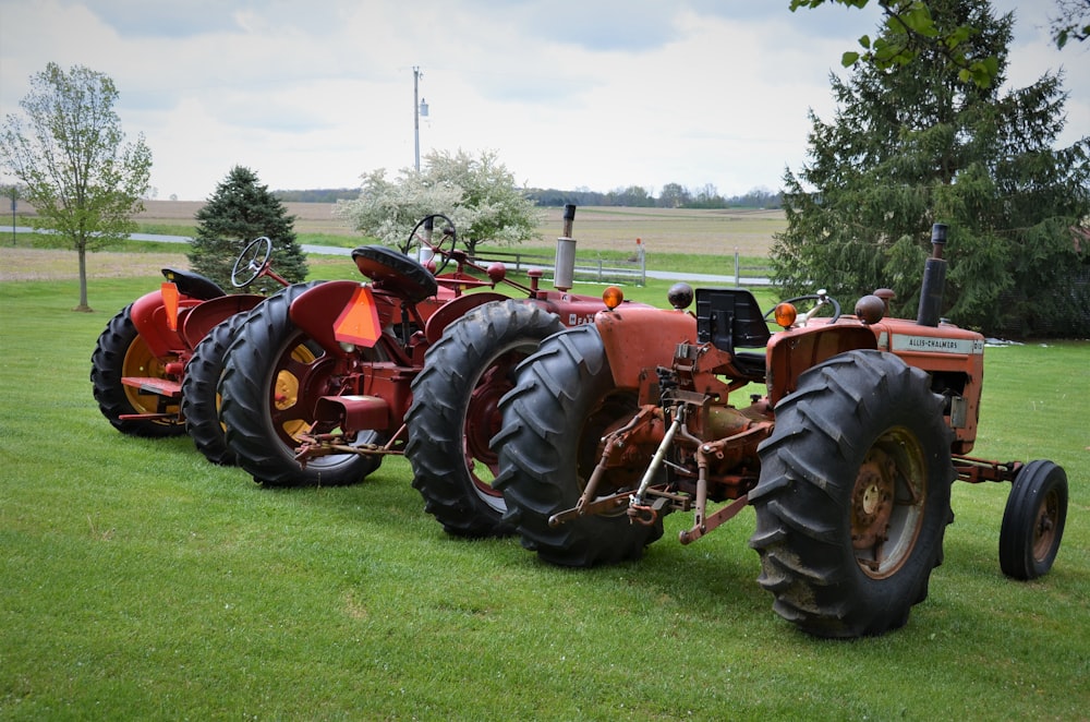 red tractor on green grass field during daytime