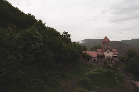 brown concrete building on green grass field during daytime in Vahanavank Monastery Armenia