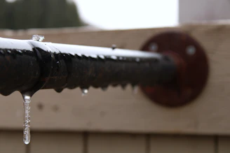 Close-up of a frozen pipe monitoring device installed inside a cottage basement.