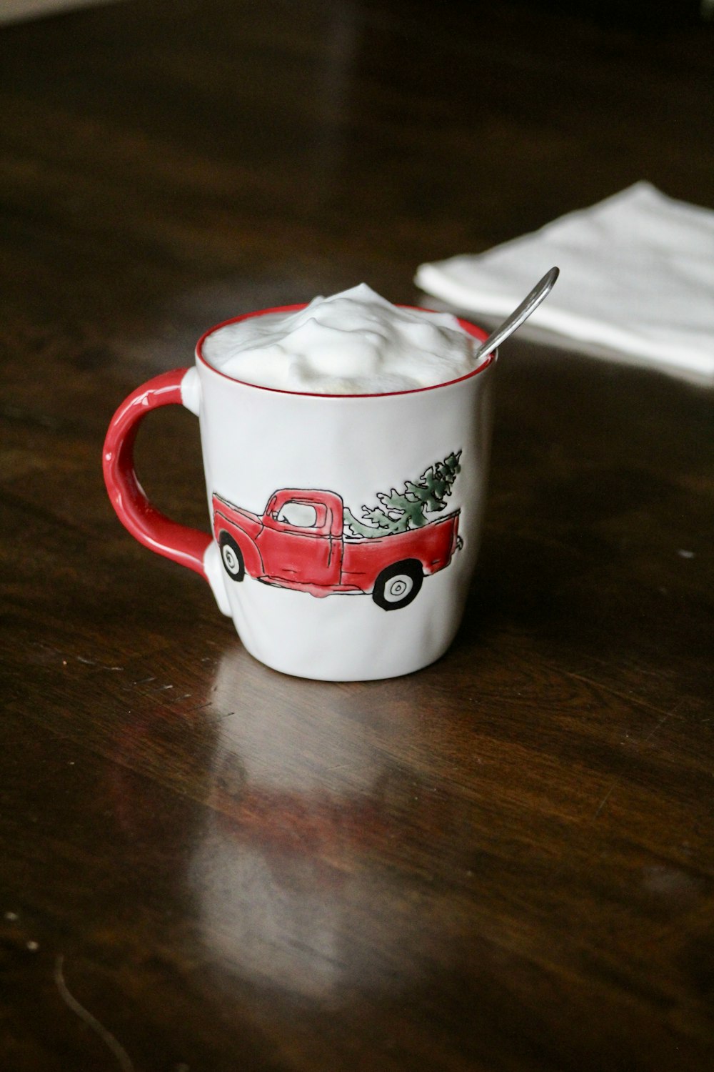 white and red ceramic mug with spoon