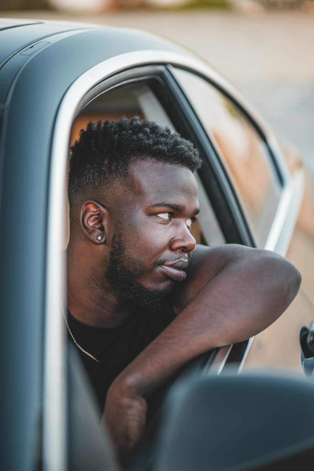 man in black tank top inside car