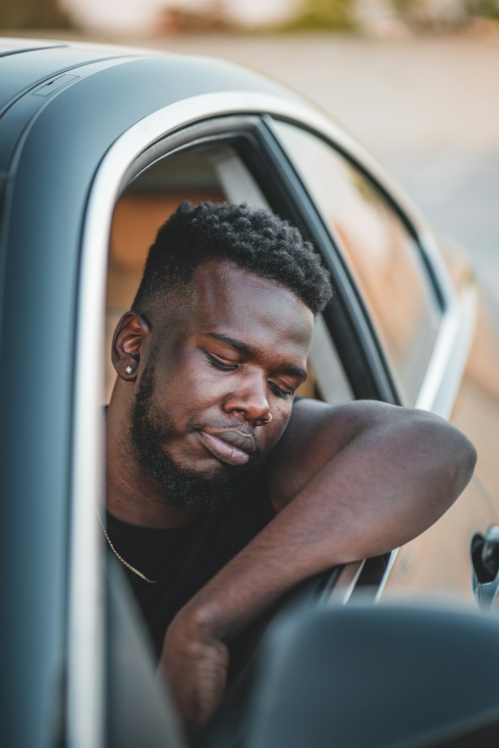 Mann in weißem Tanktop sitzt im Auto