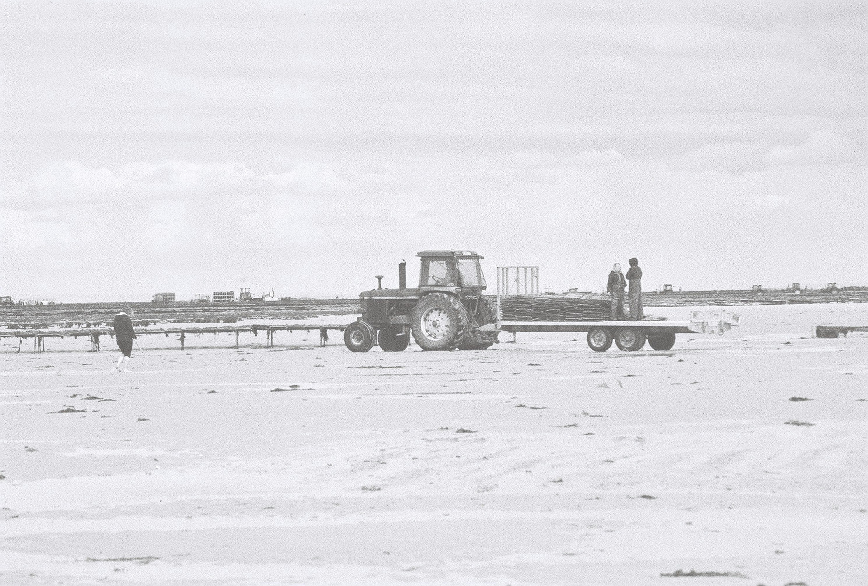 2 men standing beside truck on snow covered field during daytime