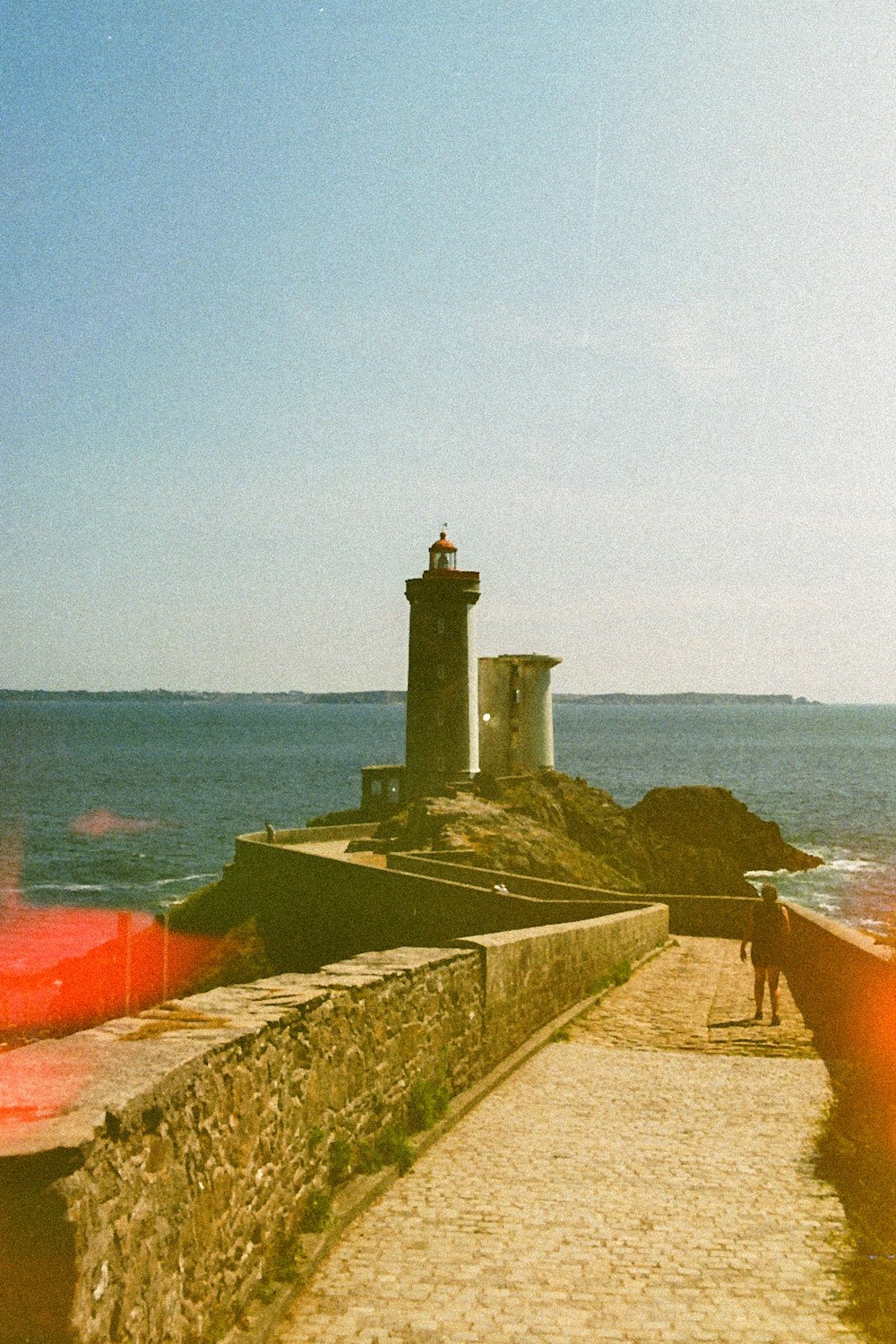 white lighthouse near body of water during daytime