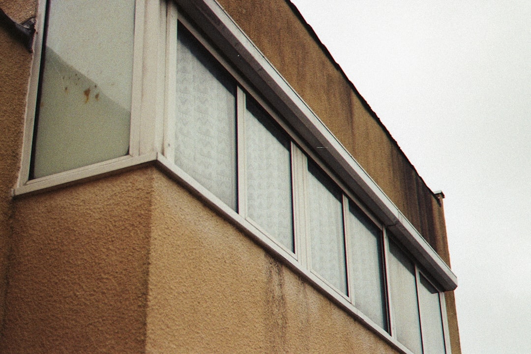 white framed glass window on brown concrete building