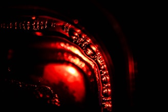 Abstract close-up of glowing red particles swirling on black glass surface.