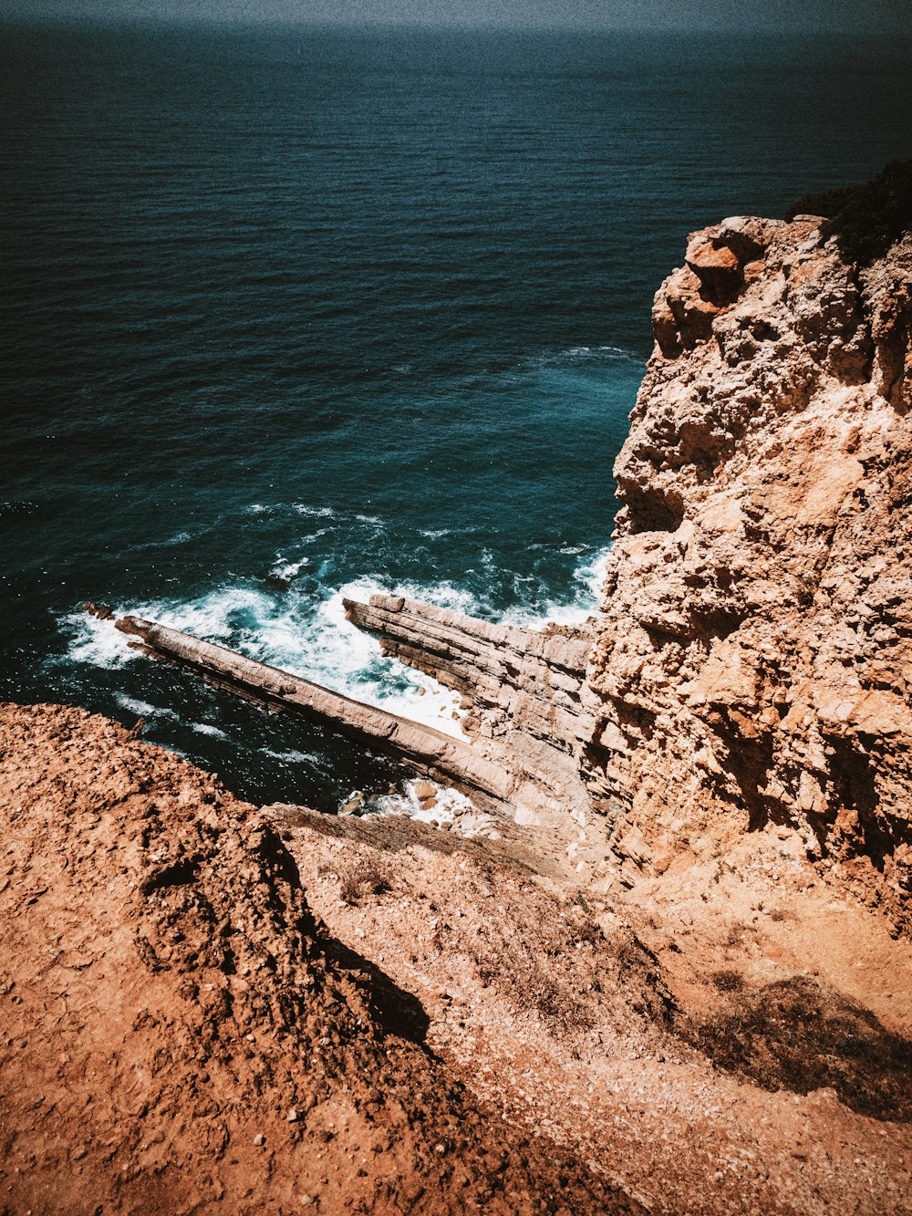 brown rock formation beside body of water during daytime