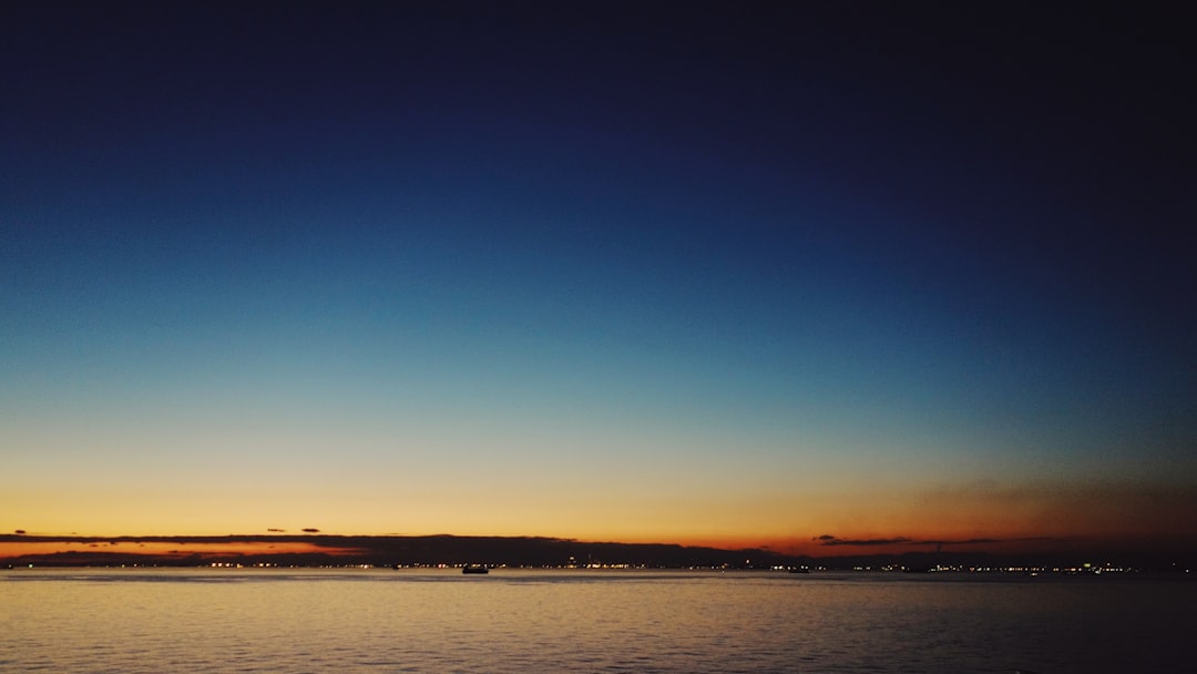 body of water under blue sky during sunset