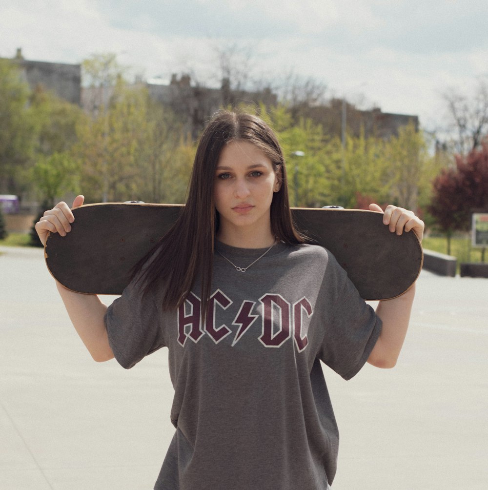 woman in gray and white crew neck t-shirt holding her hat