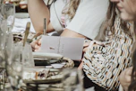 woman in white shirt holding pen and white paper
