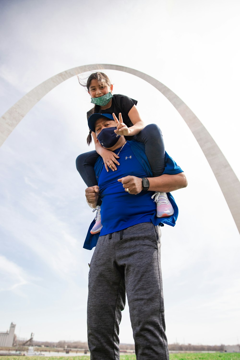 man in blue shirt carrying girl in blue shirt