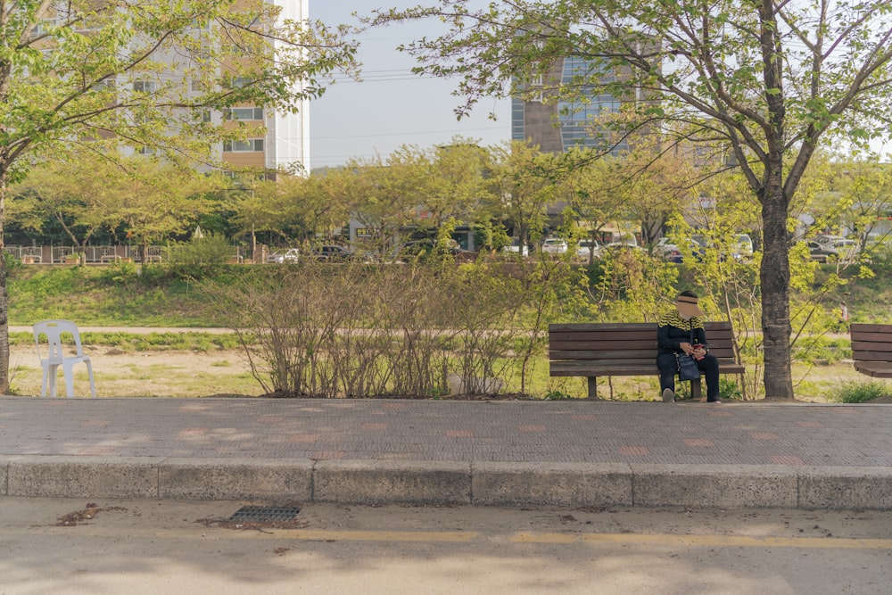 brown wooden bench on gray concrete road