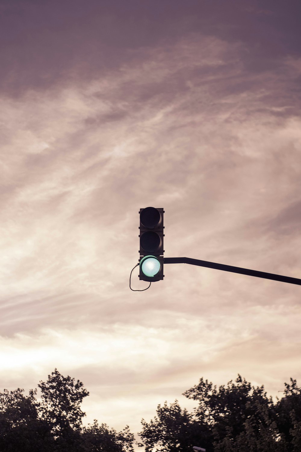 black traffic light under cloudy sky