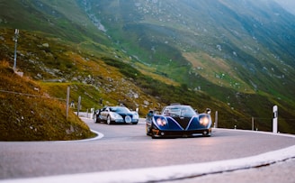 A dynamic shot of a popular automotive influencer filming a sleek sports car on a scenic mountain road.