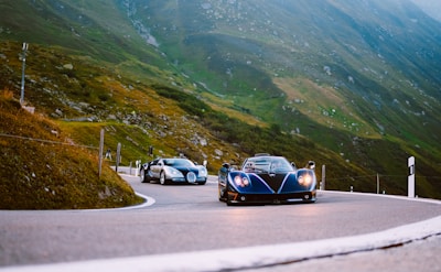 A dynamic shot of a popular automotive influencer filming a sleek sports car on a scenic mountain road.