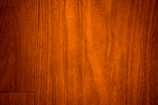 Close-up of smooth walnut wood grain with warm brown tones