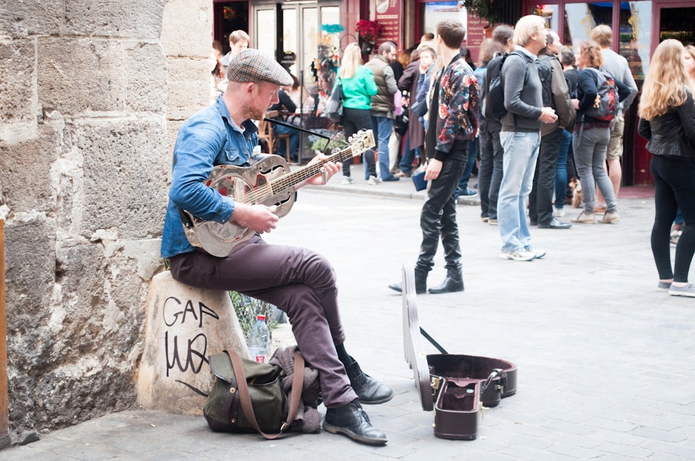 man in blue and white stripe dress shirt playing saxophone