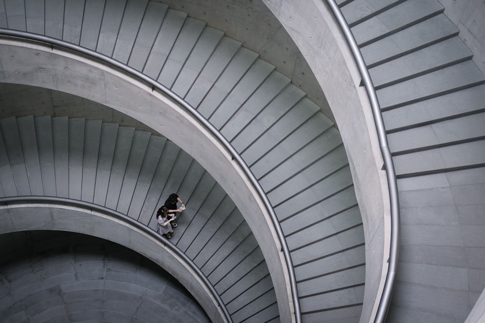 man in black jacket walking on spiral staircase