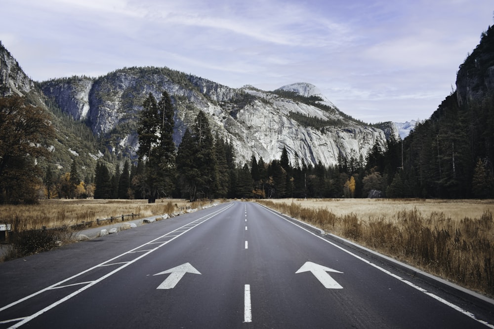 gray concrete road near mountain during daytime