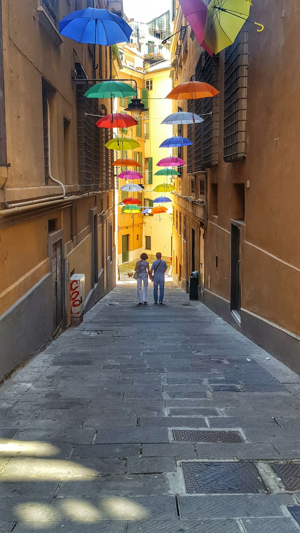 man in yellow shirt walking on sidewalk during daytime