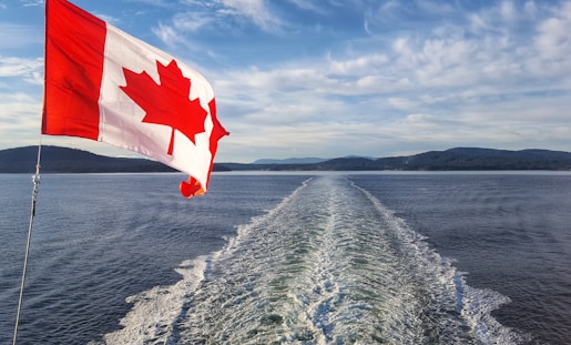 red and white flag on body of water during daytime