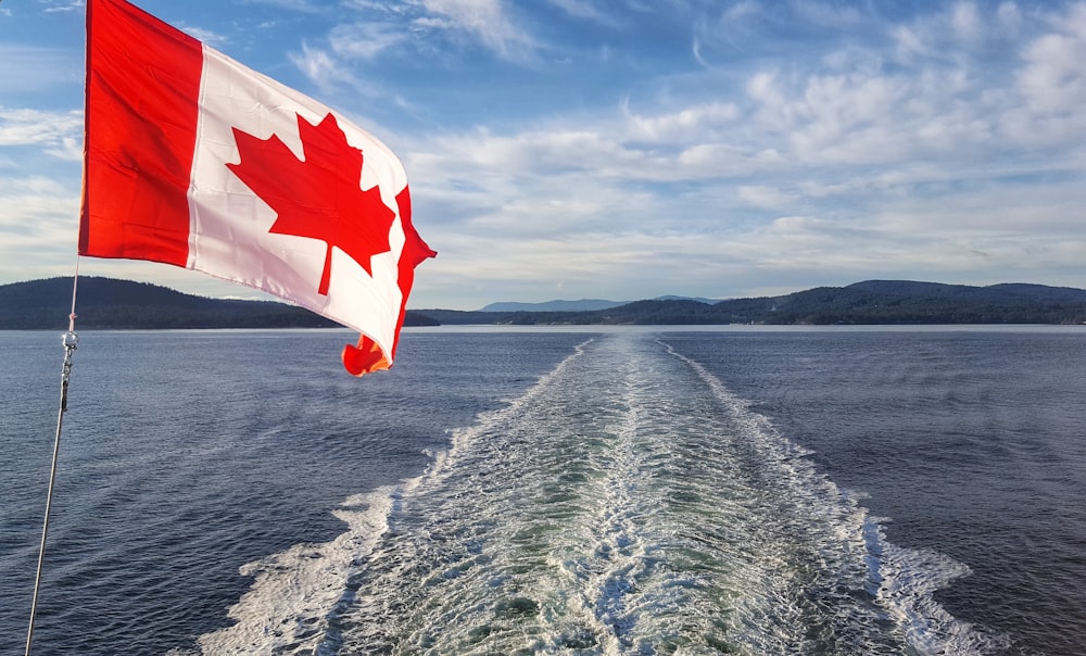 red and white flag on body of water during daytime